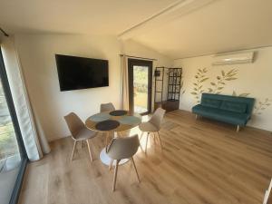 a living room with a table and chairs and a couch at Amici del Colle - Olive Tiny Houses in Borgo a Buggiano