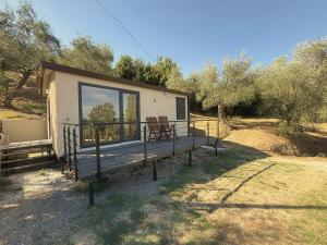a house with a deck with a bench on it at Amici del Colle - Olive Tiny Houses in Borgo a Buggiano