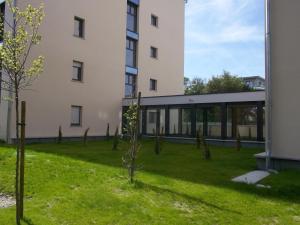 a building with a green yard next to a building at Lagrange Aparthotel Toulouse Saint-Michel in Toulouse