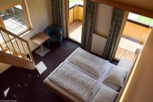 einen Blick über ein Schlafzimmer mit einem Bett und zwei Fenstern in der Unterkunft Hotel Forelle in Plansee