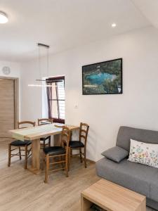 a living room with a table and a couch at Apartmaji Kramar Rateče in Kranjska Gora