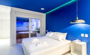 a blue bedroom with a white bed and a blue wall at Leblon Motel in Barretos
