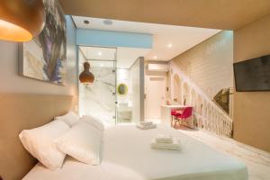 a bedroom with a white bed and a tv at Leblon Motel in Barretos