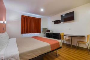 a hotel room with a bed and a table and a tv at Atlantic Inn Marshalltown, Iowa in Marshalltown +3 photos