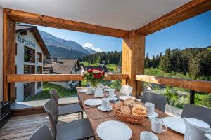 ein Tisch auf einem Balkon mit Blick auf einen Berg in der Unterkunft Turrabuel in Parpan
