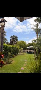 a view of a garden with palm trees and a building at Villa à Bouznika Bay-plage et golf in Bouznika