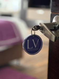a key chain attached to a door with the letterlv at LV Hoteles in Viña del Mar