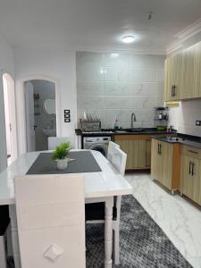 a large kitchen with a white table and chairs at Chez Cat & Lolo in Quseir