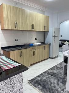 a kitchen with wooden cabinets and a refrigerator at Chez Cat & Lolo in Quseir +5 photos
