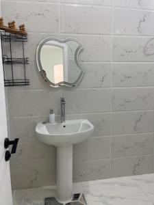 a bathroom with a sink and a mirror on the wall at Chez Cat & Lolo in Quseir