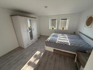a bedroom with a bed and two windows at Dorfquartier am Gut in Remstädt