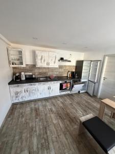 a kitchen with white cabinets and a wooden floor at Dorfquartier am Gut in Remstädt