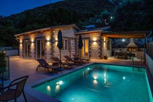 a villa with a swimming pool at night at Villa Mario by Villa Plus in Katokhórion
