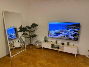 a living room with a large flat screen tv on a wall at The Art Ceiling Loft at Main Square in Prishtinë