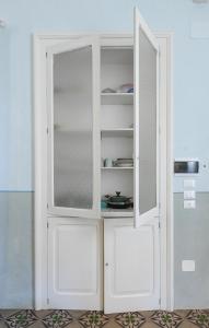 a white cabinet with two doors in a room at Dimora San Vito in Lequile