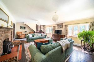 a living room with two couches and a fireplace at Primrose Spinney in Ringwood