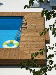 a swimming pool with a wooden deck next to a swimming pool at The Beach House in Vasilika