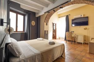 a bedroom with a bed and a desk in a room at Capomulini Boutique Hotel in Capo Mulini