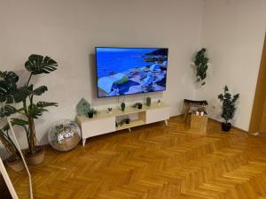 a living room with a large flat screen tv on the wall at The Art Ceiling Loft at Main Square in Prishtinë +2 photos