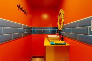 a red bathroom with a sink and a mirror at Casita in Placencia +8 photos