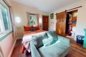 a bedroom with a bed and a couch at Casita in Placencia