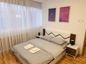 a bedroom with a bed with two towels on it at The Art Ceiling Loft at Main Square in Prishtinë