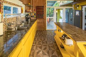 a yellow kitchen with a sink and a counter at 2 Coco Locos at Sunset in Seine Bight Village