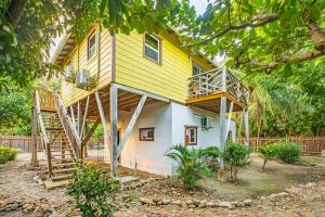 a yellow and white house with a staircase at 2 Coco Locos at Sunset in Seine Bight Village
