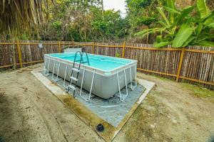 a bath tub sitting in a yard next to a fence at 2 Coco Locos at Sunset in Seine Bight Village