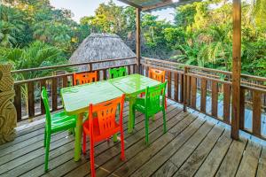 a wooden deck with a table and chairs on it at 2 Coco Locos at Sunset in Seine Bight Village +39 photos