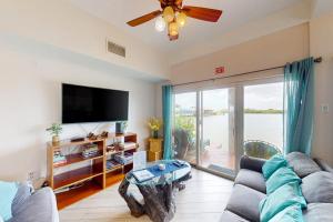 a living room with a couch and a flat screen tv at Suite H103 @ Mara Laguna in San Pedro