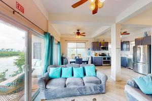 a living room with a couch and a kitchen at Suite H103 @ Mara Laguna in San Pedro