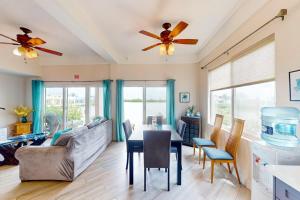 a living room with a ceiling fan and a table at Suite H103 @ Mara Laguna in San Pedro