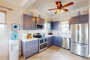 a kitchen with blue cabinets and a ceiling fan at Suite H103 @ Mara Laguna in San Pedro +14 photos