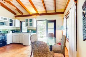 a kitchen with a glass table and chairs in it at Condo #26 @ Beachside Villas in Placencia
