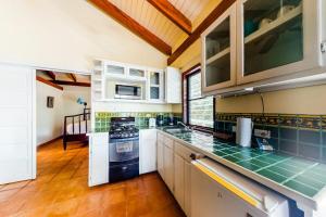 a kitchen with white cabinets and green counter tops at Condo #26 @ Beachside Villas in Placencia +27 photos