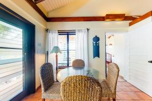 a dining room with a glass table and chairs at Condo #26 @ Beachside Villas in Placencia