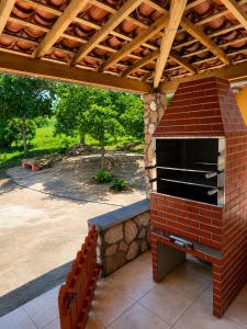 a brick oven on a patio with a wooden roof at Chácara Aconchegante com Piscina e Churrasqueira Perto do Ponto Turístico de Bezerros in Bezerros