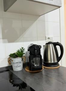 a coffee pot and a tea kettle on a kitchen counter at Enjoy and Fly, NEAR THE AIRPORT AND THE SEA in Fiumicino +15 photos