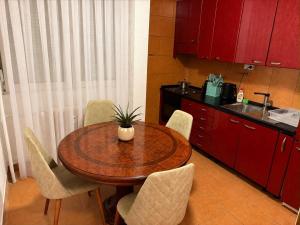 a kitchen with a wooden table with chairs and a sink at The Art Ceiling Loft at Main Square in Prishtinë