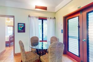 a dining room with a glass table and chairs at Condo #25 @ Beachside Villas in Placencia