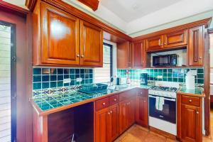 a kitchen with wooden cabinets and a stove top oven at Condo #25 @ Beachside Villas in Placencia