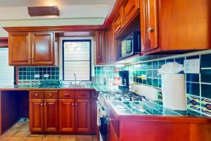 a kitchen with wooden cabinets and a stove top oven at Condo #25 @ Beachside Villas in Placencia +17 photos