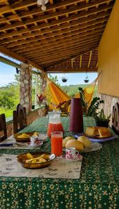 a table with a green table cloth with food on it at Chácara Aconchegante com Piscina e Churrasqueira Perto do Ponto Turístico de Bezerros in Bezerros