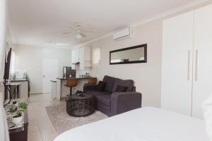 a white living room with a couch and a kitchen at Edenvale corner in Edenvale