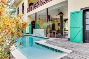 a house with a swimming pool and a patio with a table at Crow's Nest Suite at Mahogany Hall -Gold Standard Certified in San Ignacio