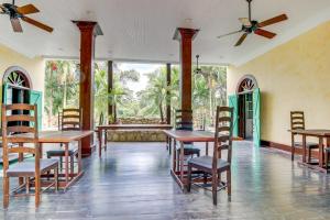 a dining room with tables and chairs and windows at Crow's Nest Suite at Mahogany Hall -Gold Standard Certified in San Ignacio