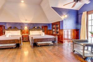 a bedroom with two beds and a blue wall at Crow's Nest Suite at Mahogany Hall -Gold Standard Certified in San Ignacio
