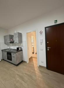 a kitchen with a stove and a door to a hallway at Enjoy and Fly, NEAR THE AIRPORT AND THE SEA in Fiumicino