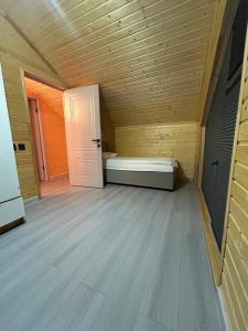 a small room with a bed and an open door at MMED SWEET HOMe in Bosteri